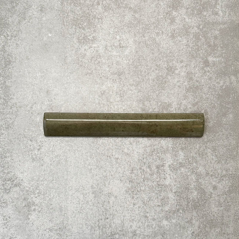Nomad Sage Green bullnose pencil border ceramic tile in a 3 × 20cm format, featuring a glossy glaze and subtle colour variation, ideal for finishing edges and transitions alongside matching brick wall tiles.