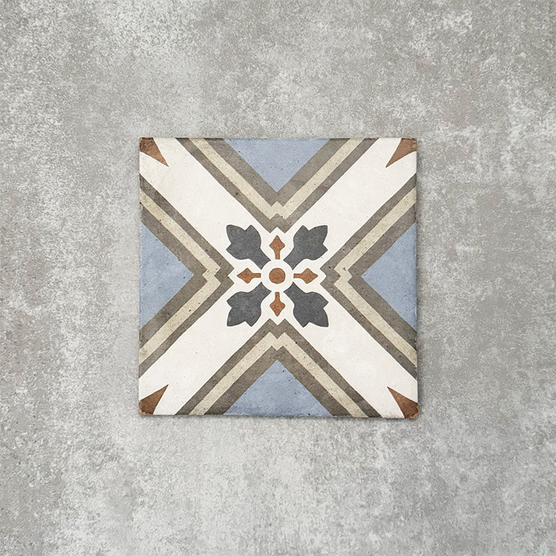 Viscount Turner 20×20cm Victorian-style porcelain wall and floor tile featuring a geometric cross and floral-inspired motif in soft blue, white, grey and warm beige tones, photographed as a single tile on a neutral grey background.