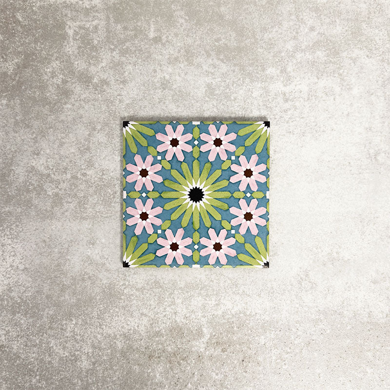 Single Fez Mini Summer 15x15cm Moroccan-style porcelain tile displayed against a textured grey background, highlighting the colourful geometric star pattern in soft green, blue and blush pink tones with an encaustic-inspired finish.
