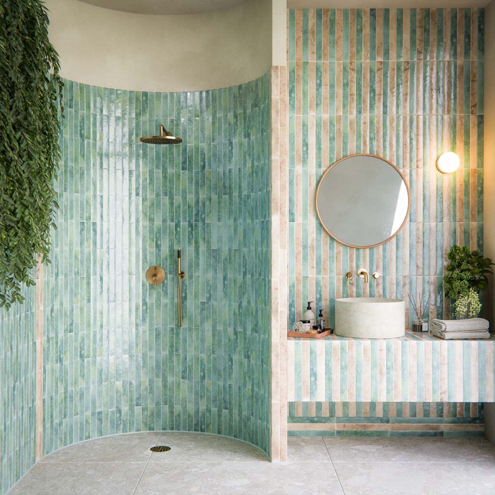 Bathroom interior featuring Essentials Terrazzo Stone Avorio 60x120cm terrazzo effect porcelain floor tiles, paired with vertically laid green and beige glazed wall tiles, a curved walk-in shower, and a floating vanity with round basin.