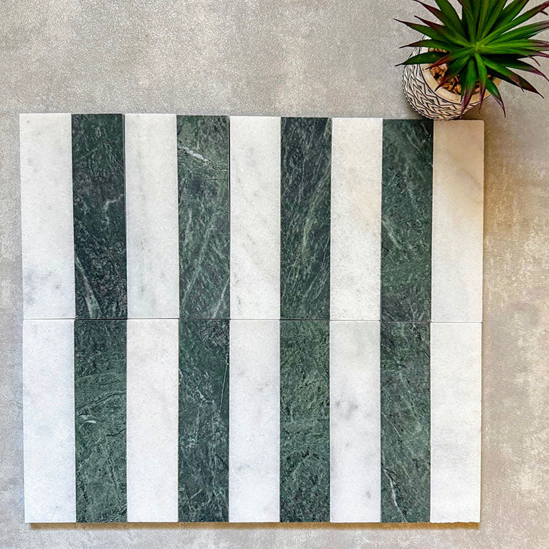 Arrangement featuring Fayrouz White 5x20cm natural marble tiles with a honed finish, paired with green marble pieces in a striped layout, highlighting soft white tones with subtle grey veining alongside rich green variation for contrast and visual interest.