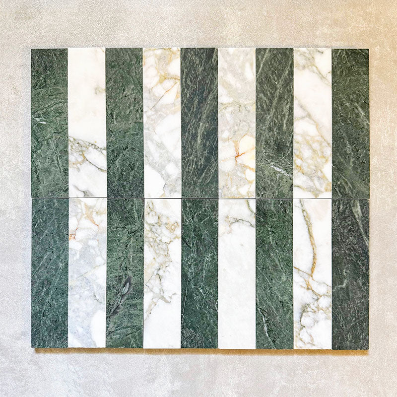 Arrangement featuring Fayrouz Calacatta Green 5x20cm natural marble tiles with a honed finish, displayed in a striped layout alternating green and white marble pieces to highlight natural veining and tonal variation against a neutral backdrop.