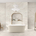 Bathroom interior featuring Taj Mahal Matt 60 × 120cm marble effect porcelain wall and floor tiles, showcasing soft cream tones with gentle, flowing veining. The larger format enhances the sense of space, creating a seamless, spa-like setting complemented by warm wood accents and soft, natural light.