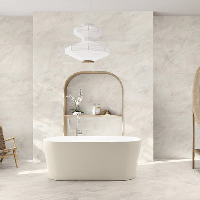 Bathroom interior featuring Taj Mahal Matt 60 × 120cm marble effect porcelain wall and floor tiles, showcasing soft cream tones with gentle, flowing veining. The larger format enhances the sense of space, creating a seamless, spa-like setting complemented by warm wood accents and soft, natural light.