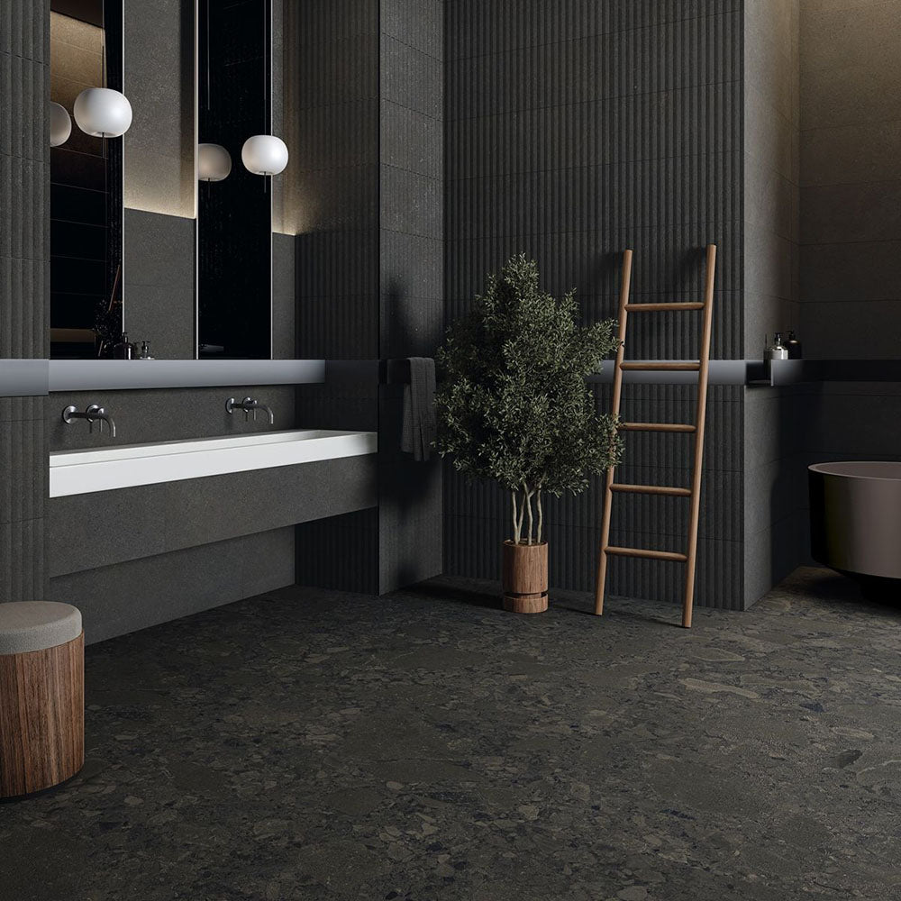 Modern bathroom featuring Terrazerri Terrazzo Black 60x60cm porcelain tiles on the floor and walls. The dark charcoal terrazzo effect creates a bold, contemporary look, paired with fluted wall panels, a floating white vanity, timber accents and soft globe lighting for a sophisticated, luxurious finish.