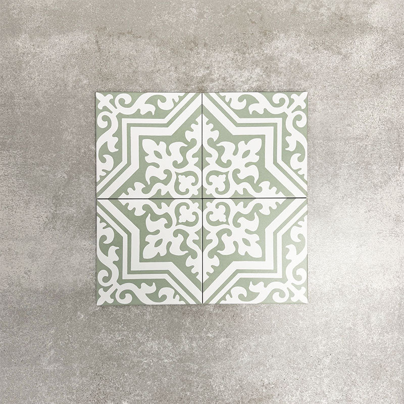 London Streets Thornton Place Sage Green 20cm x 20cm Victorian Moroccan style ceramic tiles arranged as four pieces to create a decorative star pattern, featuring intricate white detailing on a soft sage green background.