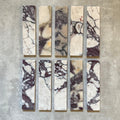 Fayrouz Viola 5x20cm natural marble tiles with a honed finish, featuring a white base with bold burgundy and warm-toned veining, arranged in a neat grid to highlight natural variation and distinctive stone detail.