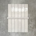 Nomad White bullnose pencil border ceramic tiles in a 3 × 20cm format, shown with matching brick tiles to highlight the coordinating white colour, gloss finish and rounded edge detail.