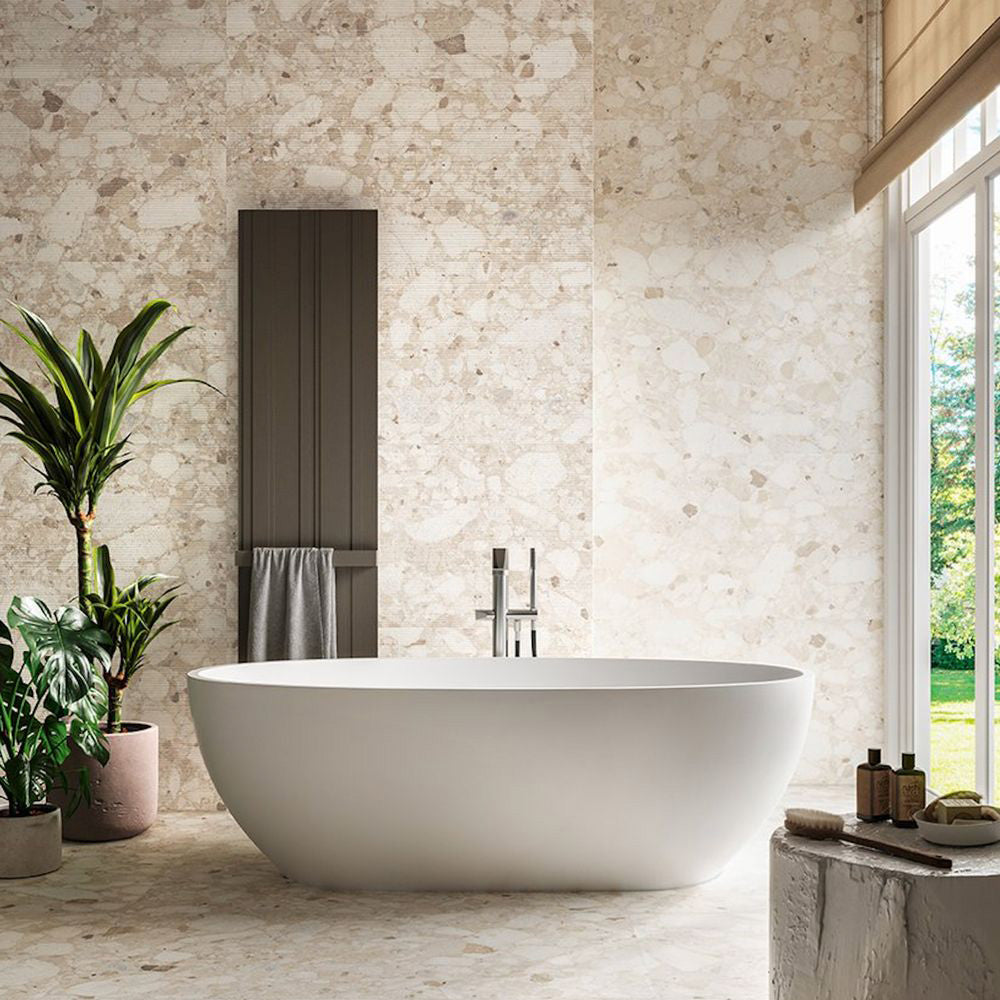 Luxury bathroom featuring Venice Ivory matt terrazzo effect porcelain tiles in a 60 x 120cm format across the walls and floor, creating a bright, seamless space with a freestanding bath and natural stone-inspired finish.
