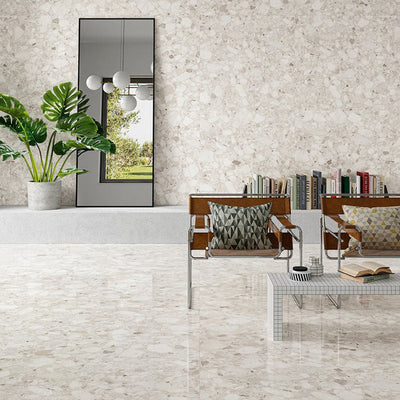 Contemporary living space featuring Venice Ivory polished terrazzo effect porcelain wall and floor tiles, showcasing soft ivory tones with natural stone chips, paired with modern furniture and greenery for a bright, elegant interior.