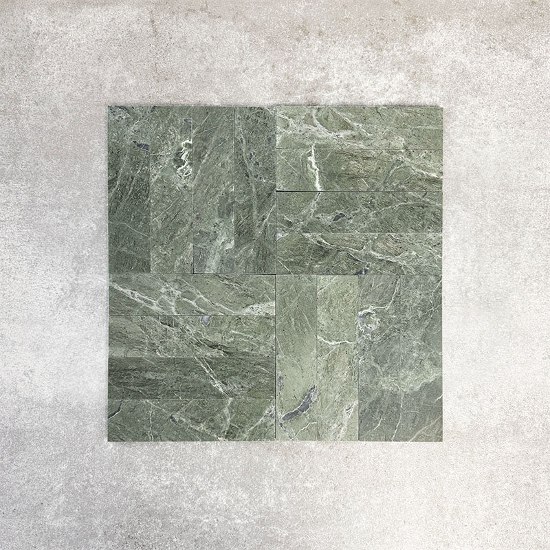 Arrangement featuring Fayrouz Verde 5x20cm natural marble tiles with a honed finish, laid in a basketweave-style pattern, showcasing rich green tones, varied veining and natural movement against a neutral background.