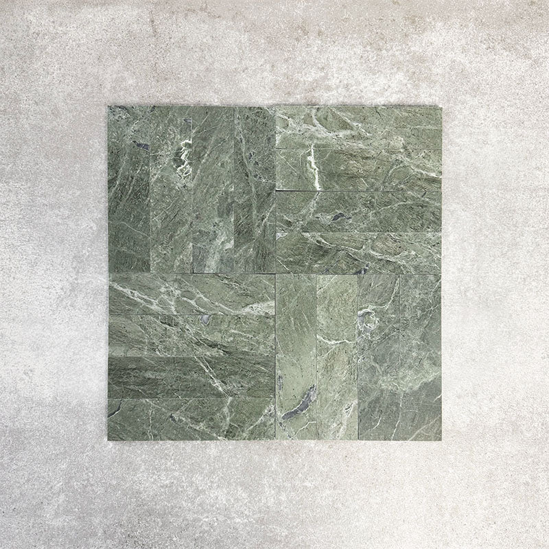 Arrangement featuring Fayrouz Verde 5x20cm natural marble tiles with a honed finish, laid in a basketweave-style pattern, showcasing rich green tones, varied veining and natural movement against a neutral background.