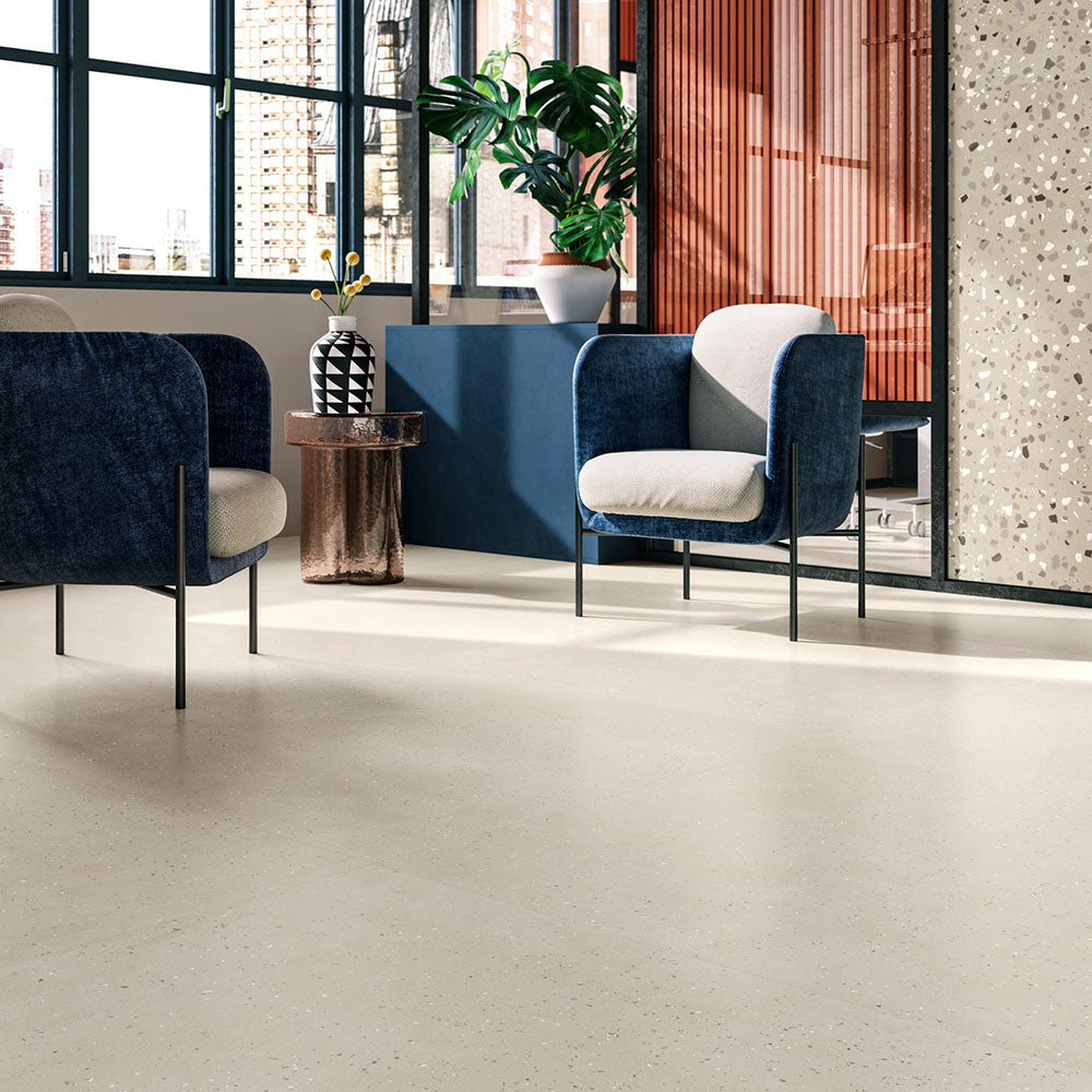 Contemporary commercial interior featuring Verona Micro Sand concrete effect porcelain floor tiles, styled with modern lounge seating, black-framed glazing, timber slatted partitions, indoor planting and minimalist architectural details.