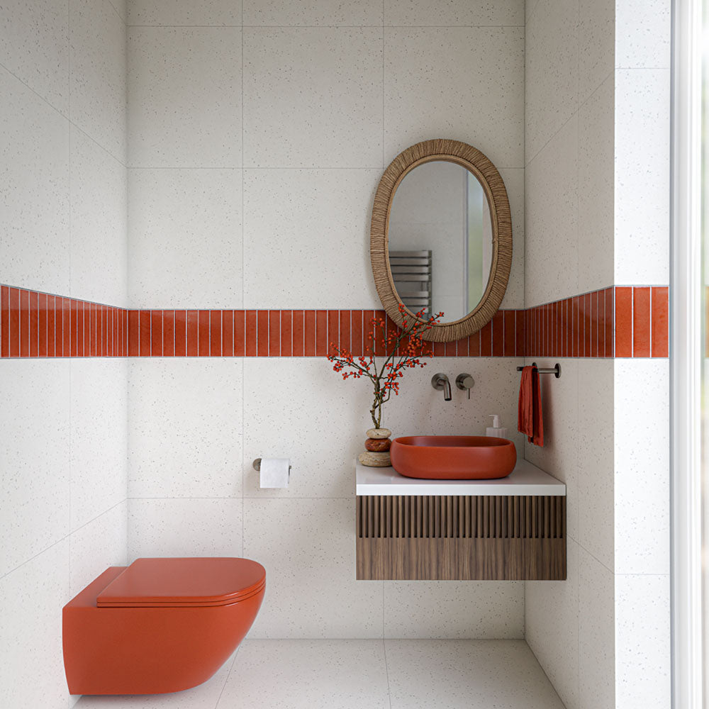 Verona Micro White 60cm x 60cm terrazzo effect porcelain tiles covering the walls and floor of a modern bathroom, paired with a coral tile feature strip, matching coral sanitaryware and a warm wood vanity.