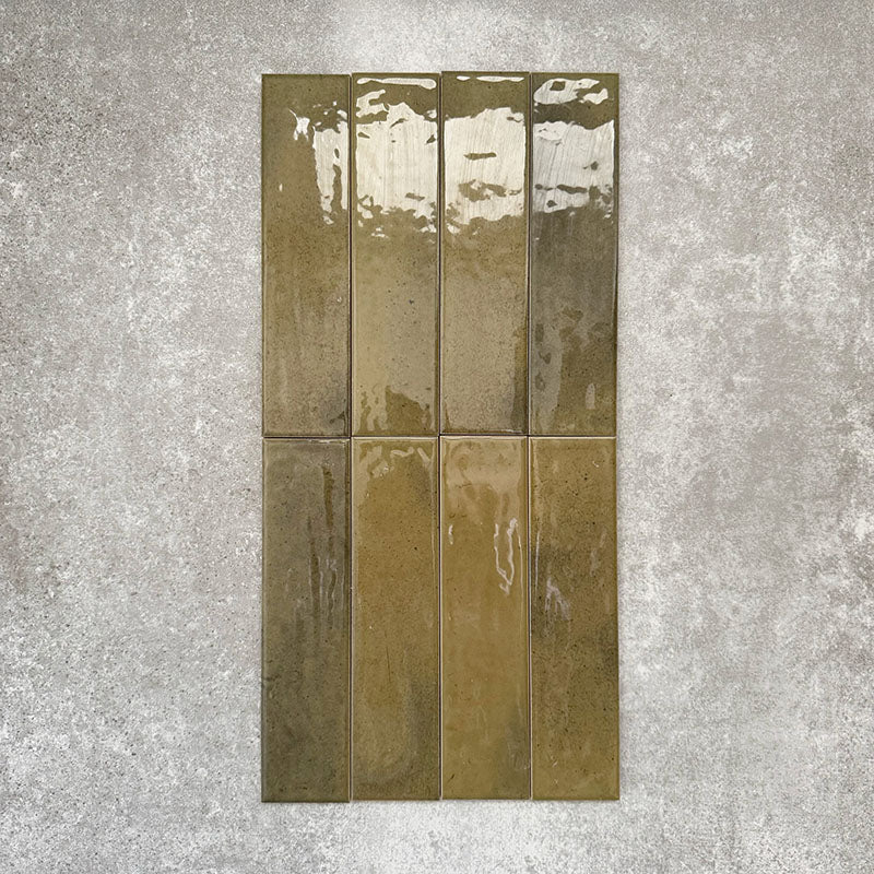 Allegra Daisy Green Gloss Brick ceramic tiles in a 6 × 25cm format, shown laid vertically to highlight the rich green tones, glossy finish and subtle handmade-style surface variation.