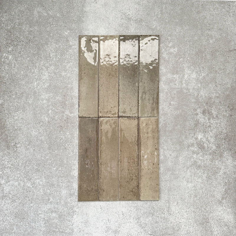 Allegra Sage Green Gloss Brick ceramic tiles in a 6 × 25cm format, shown laid vertically to highlight the muted green tones, glossy finish and subtle handmade-style surface variation.