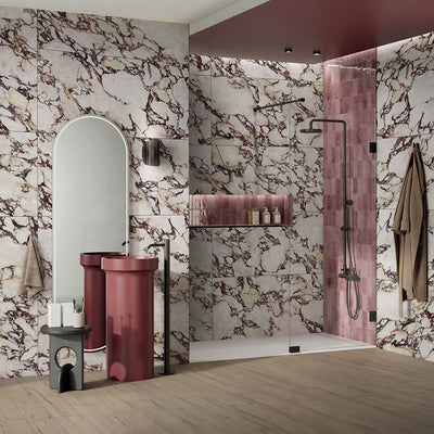 Bathroom interior featuring Viola Matt Honed Marble effect 60 × 120cm porcelain wall tiles, styled with a walk-in shower, burgundy vanity units, soft pink feature tiles, and bold veining creating a striking, design-led space.