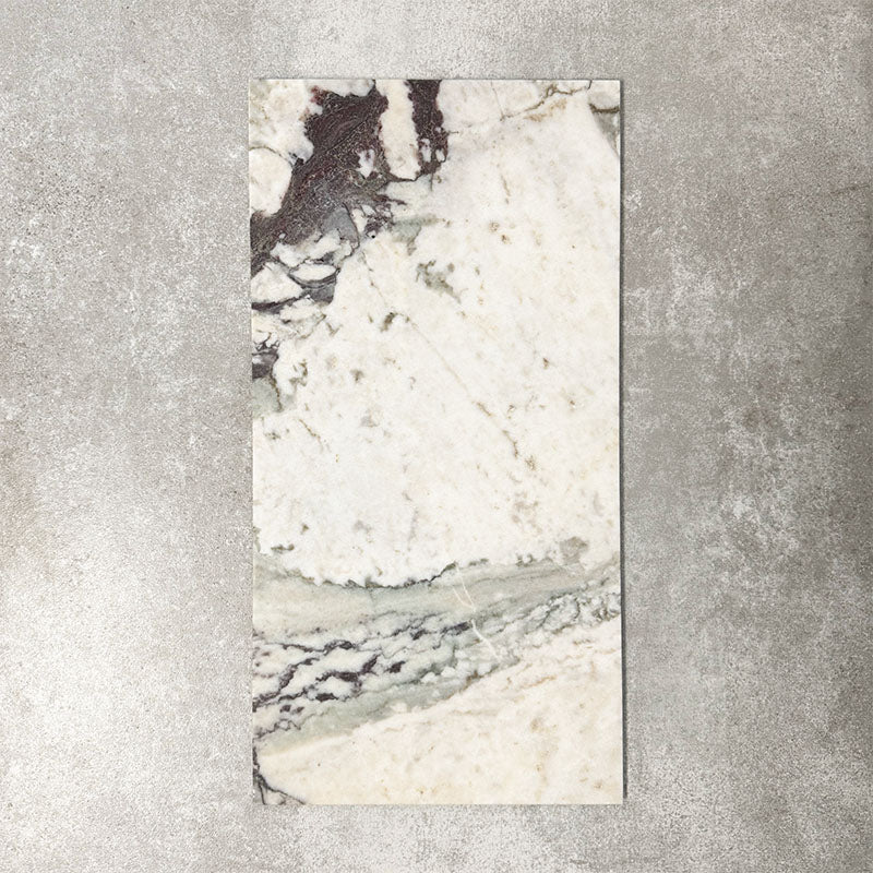 Fayrouz Viola 30.5x61cm natural marble tiles with a honed finish, featuring a warm ivory base with bold burgundy and green veining, shown as a single tile sample against a neutral textured backdrop.