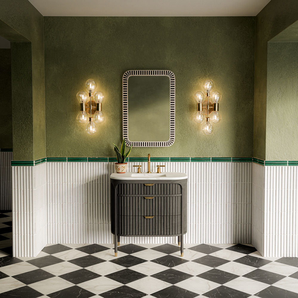 Bathroom featuring Vitoria Classic Bianco White 30cm x 30cm marble effect chequerboard floor tiles, laid in a black and white diamond pattern and paired with green walls, fluted wall tiles and brass details.