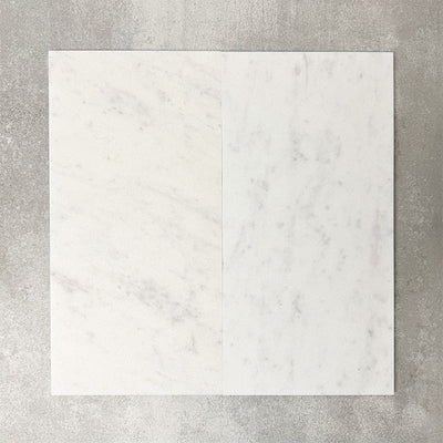 Close-up of Fayrouz White natural marble tiles in a honed finish, 30.5x61cm format, showcasing a soft white base with subtle grey veining and gentle tonal variation, creating a refined and timeless look for wall and floor applications.