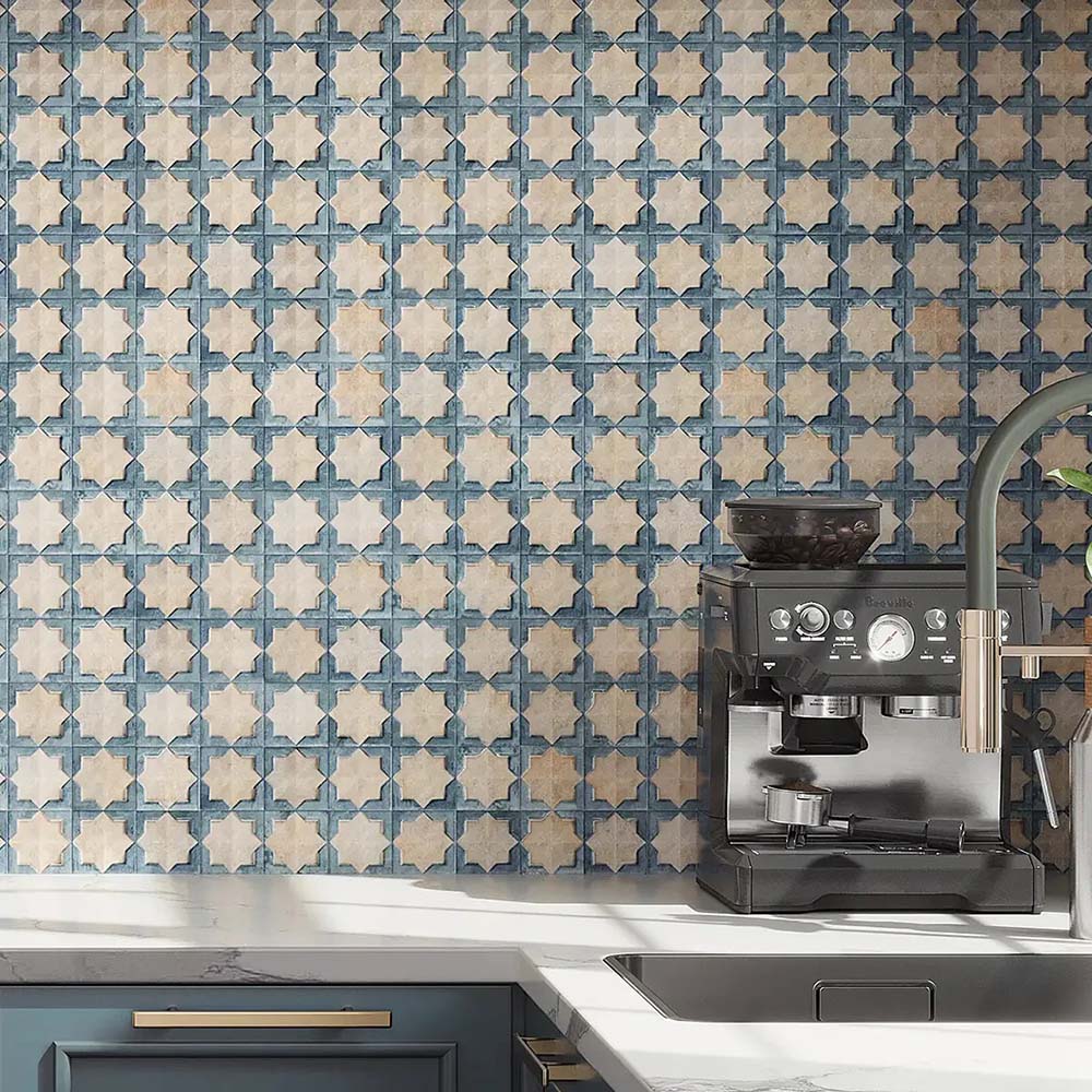 Kitchen featuring Zanzibar Moroccan Arena Blue wall tiles as a striking splashback, showcasing a blue and cream Moroccan style geometric pattern, paired with navy cabinetry, white worktops, brushed brass handles and contemporary stainless steel fixtures.