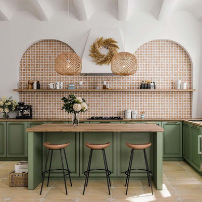 Kitchen featuring Zanzibar Moroccan Cotto White wall tiles in a warm terracotta and white Moroccan style geometric pattern, paired with sage green cabinetry, natural wood worktops, woven pendant lights and Mediterranean-inspired styling.