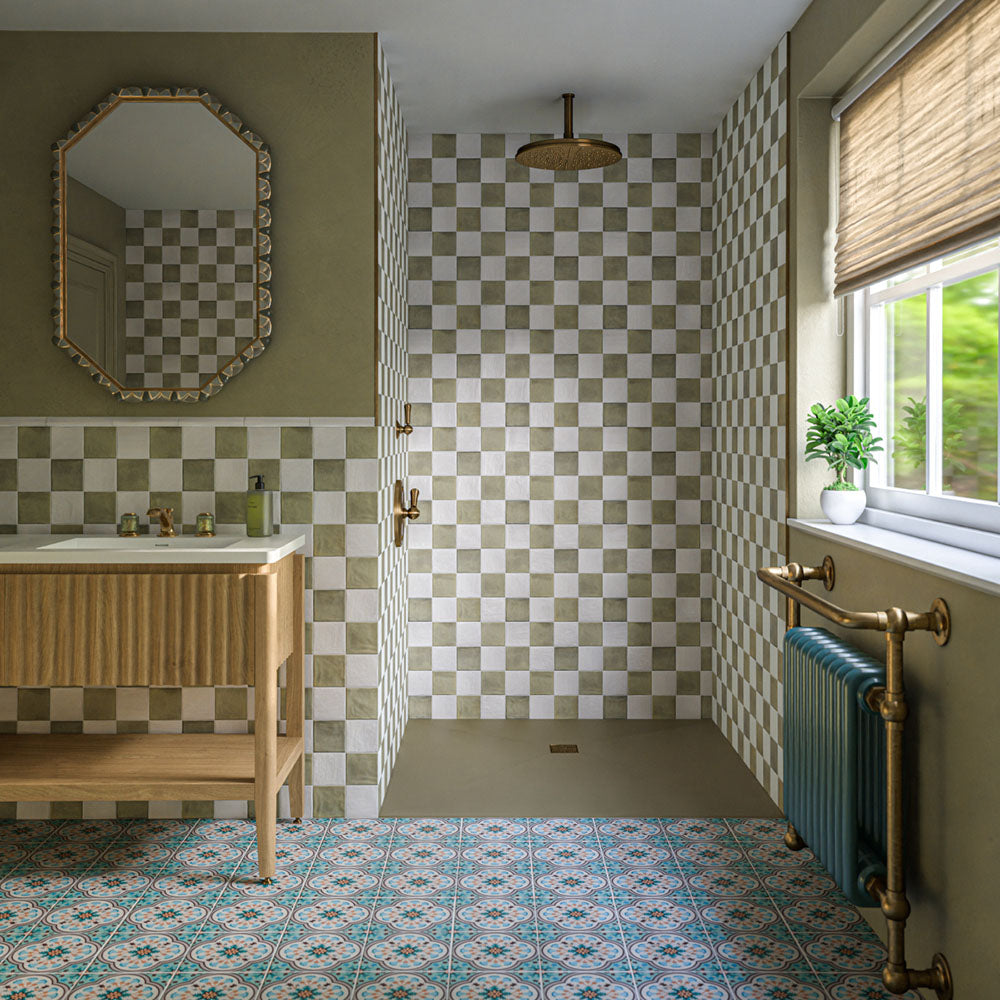 Zellige Oyster Square 10cm x 10cm Moroccan style tiles, combining soft oyster and white tones in a chequerboard layout across the bathroom walls, paired with a colourful patterned floor, warm wood and aged brass details.