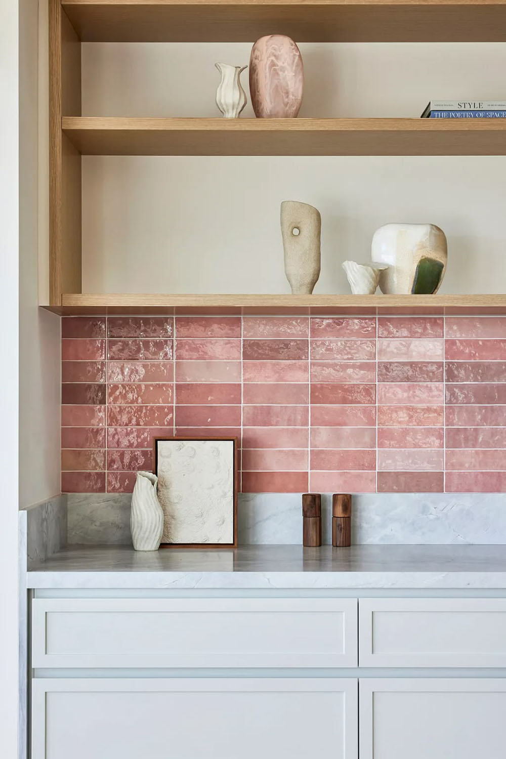 Kitchen featuring Zellige Rose Pink Brick 6.5cm x 20cm Moroccan style wall tiles as a splashback, paired with white cabinetry, marble worktops, open oak shelving and decorative ceramics for a warm, contemporary space.